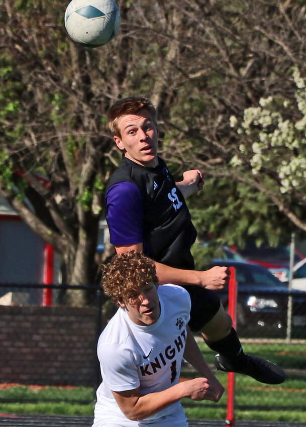 Blair senior Crayton Macholan, top, heads the ball over Norfolk Catholic/Lutheran High's Aiden Corr on Monday during the Class B-4 Subdistrict Tournament at South Sioux City. The Bears advanced to the subdistrict final with a 4-1 win against the Knights.
