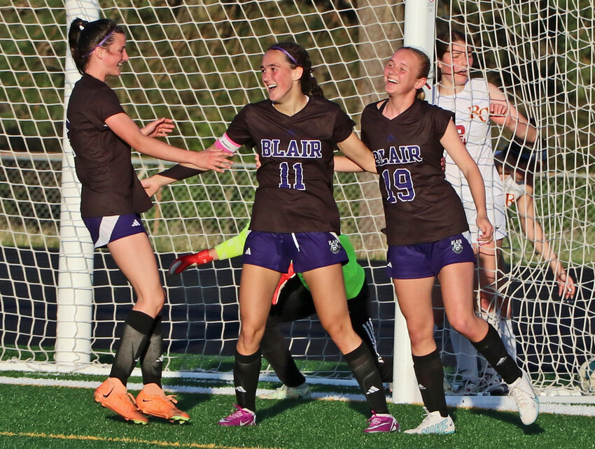 Blair junior Brynn Ray, middle, celebrates a first-half goal with teammates Laynie Brown, left, and Taytum Macholan on Tuesday at Krantz Field. The Bears beat Omaha Roncalli in subdistrict play.