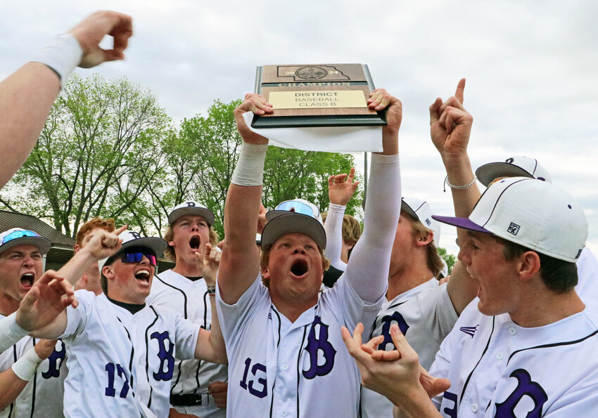 Blair senior Dyaln Swanson, middle, holds up the Class B-6 District Tournament championship plaque Friday at Vets Field. The Bears beat Platte Valley 2-1, securing the first state tournament berth since 2017.