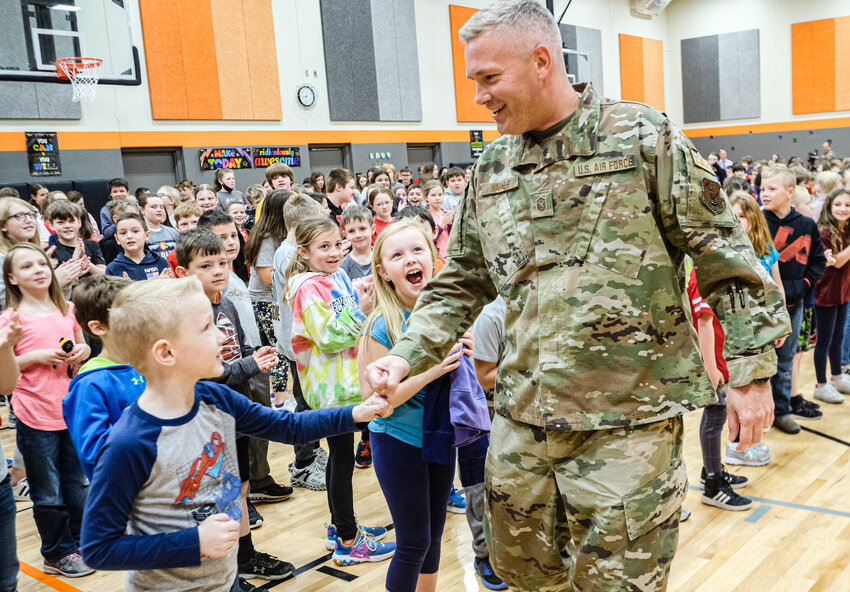 Principal Drew Wagner fist bumps students on his return home following deployment in UAE in April 2022.