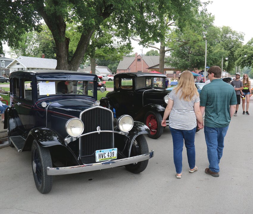 A couple walks past a 1931 Desoto Coupe at during the June 10 Car Show along 16th Street.
