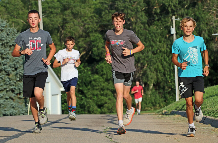 Cross-country athletes run up West Ellsworth Street on Thursday morning during Arlington High School's camp.