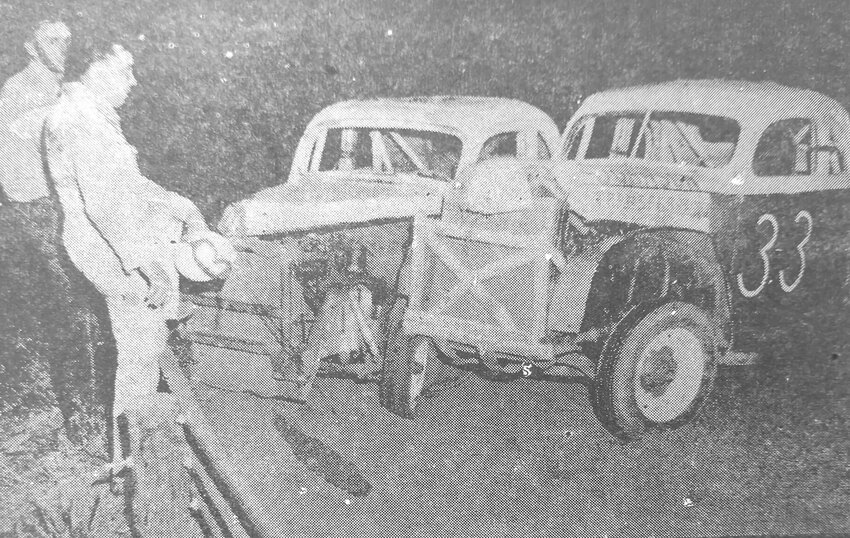 Drivers John Hines and Melvin Christ stand off to the side of the track in 1955 after their cars locked wheels and rammed into the guard rail in Arlington.