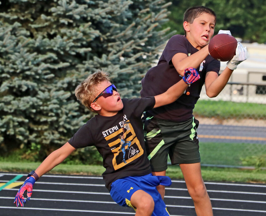 Brecken O'Connor, right, nabs a touchdown pass despite tight coverage from Grady Nelson on Tuesday at Fort Calhoun High School. About 100 kids took part during the Pioneers' youth camp this week.