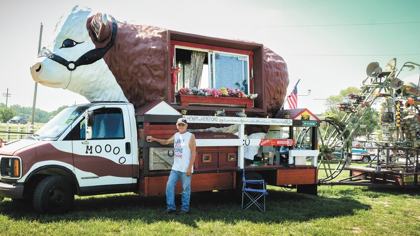 Artist and sculptor Clark Bettenhausen stands next to his Henry Hereford RV. It was on display last Saturday at the Kick'n It In The Stix car show in Arlington.