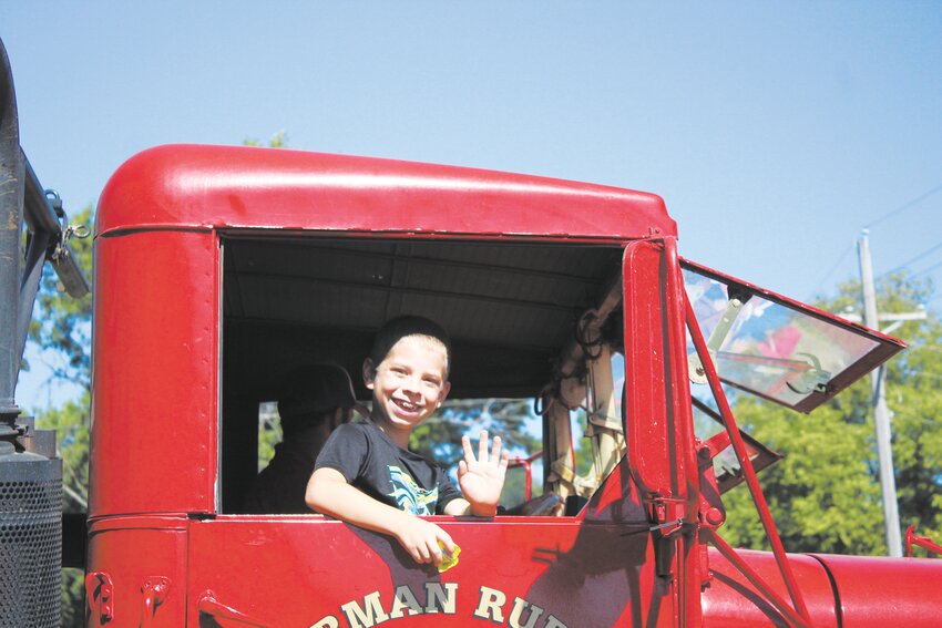 The son of a member of the Herman Fire &amp; Rescue Department waves from Fire Engine 942 during the Herman Days parade.