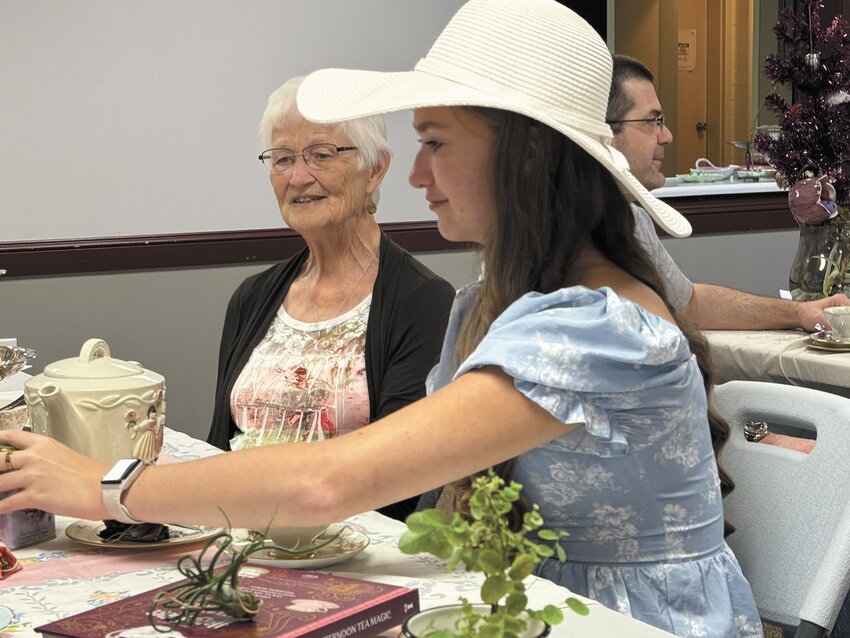 Maddie Martens, in the foreground, and Julie Young are among those enjoying Sunday's Tea Party at the Arlington Public Library.