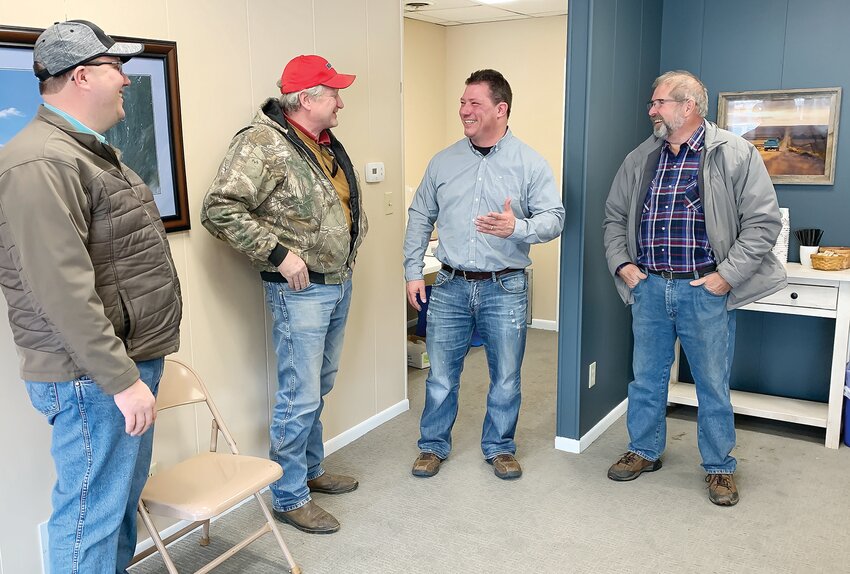 Michael Nissen, Mark Johnson and Gary Powell talk markets with Greg Mockenhaupt (third) during a GLM Commodities Open House.