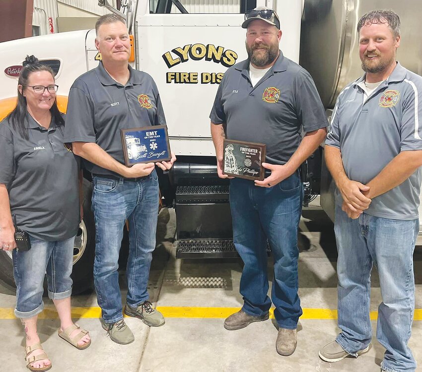 Commended for their dedication to the Lyons Fire and Rescue, Scott Burgett and Kyle Phillips received EMT and Firefighter ot the Year Awards respectively.  Pictured are, from left, Shannon Burgett, Scott Burgett, Kyle Phillips, and Chief Stuart Miller.