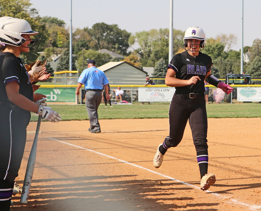 Blair slugger Jacy Schueth, right, finishes her home run trot as her teammates cheer Friday at the Youth Sports Complex.