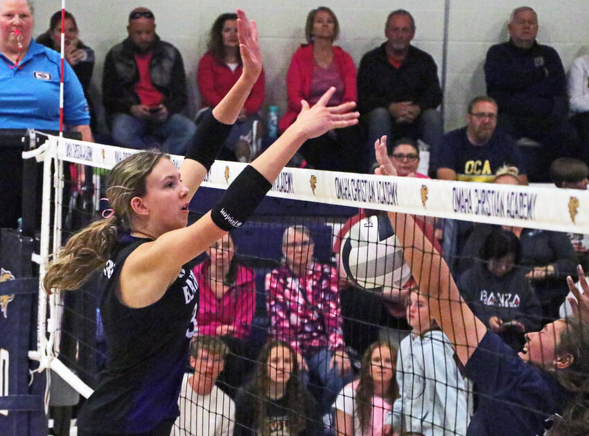 Blair junior Emma Ammon, left, blocks the ball down to the floor Tuesday at Omaha Christian Academy.