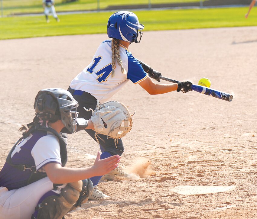 Kinley Osborn #14 lays down a perfect bunt and advances her teammates on the bases in Sub-District action against Milford.