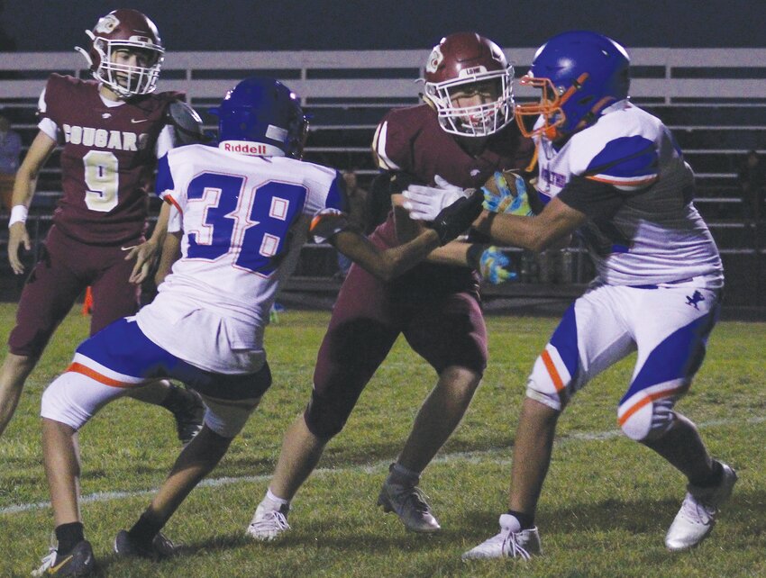 Masen Olsen watches as Kwyntin Kampa carries the ball for the Cougars.