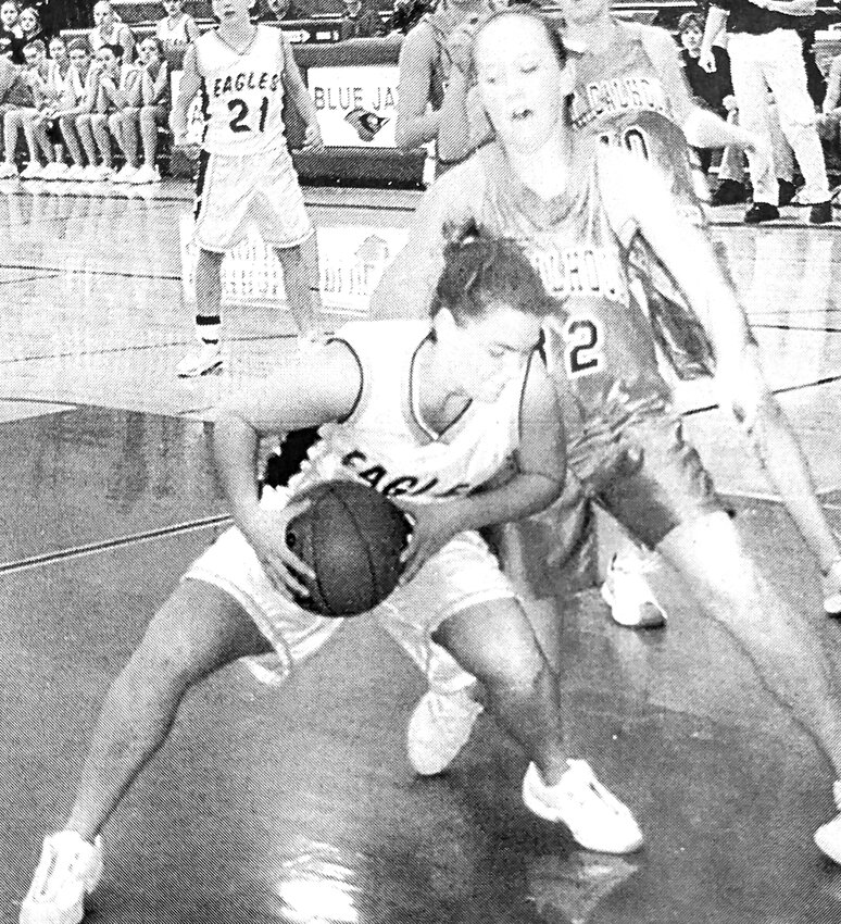 Arlington's Beth Keber is cut off on her way to the basket by Allie Oestmann of Fort Calhoun during a 2003 subdistrict game in West Point.
