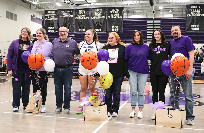 Seniors Lillian Huenink, from left, Hayden Frink-Mathis and Addie Sullivan pose for photos with their parents Thursday on Senior Night at Blair High School.