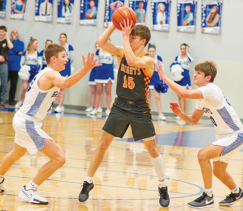 Moving the ball around the key, Dawson Meyer looks to pass the basketball.