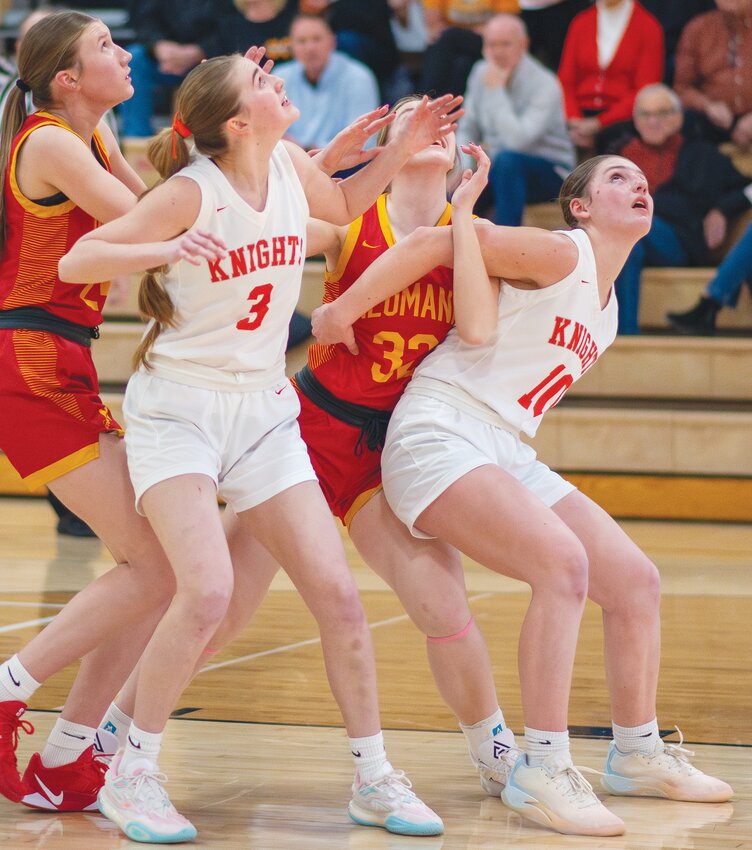 As the rebound comes down, Mia Thomsen and Hilary Ray box out the Bishop Neumann players.