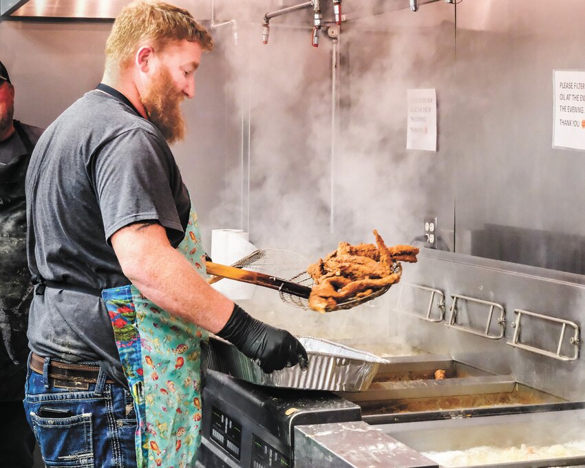 Luke Stevens ladles a batch of golden brown fish from the fryer at last Friday's fish fry at St. John the Baptist Catholic Church in Fort Calhoun.