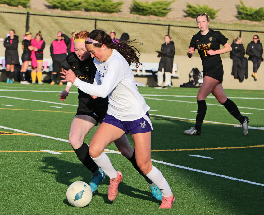 Blair senior Brynn Ray, left foreground, attacks upfield Monday at Class B No. 1 Gretna East. The Eastern Midlands Conference match was between a pair of unbeaten teams.