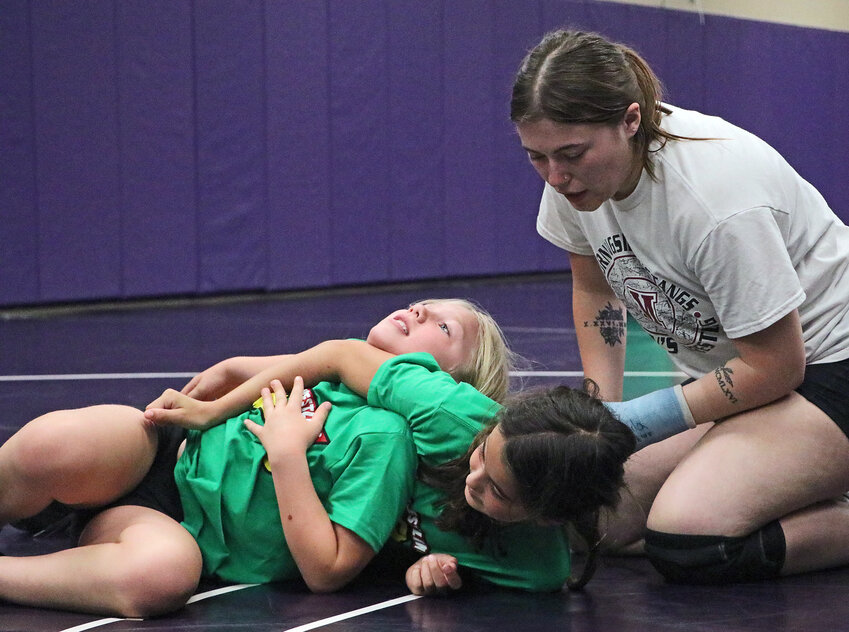 Former Bear and current Morningside University Mustang Josie Biffar, right, works with grapplers June Wallis, 9, left, and Olivia Whitwer on Thursday at Blair High School. Mustangs coach Jordan Cliff led BHS' girls camp Thursday and Friday, while Nebraska associate head coach Bryan Snyder and Hudson Loges led the boys camp.