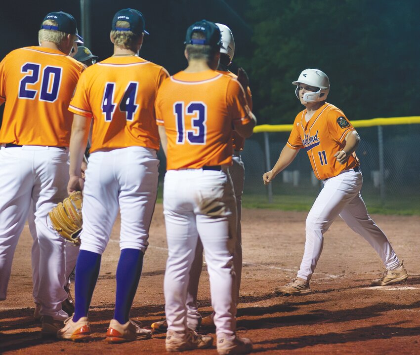 Corbin Guill crosses home and is greeted by teammates after smaking a line drive over the left field fence.