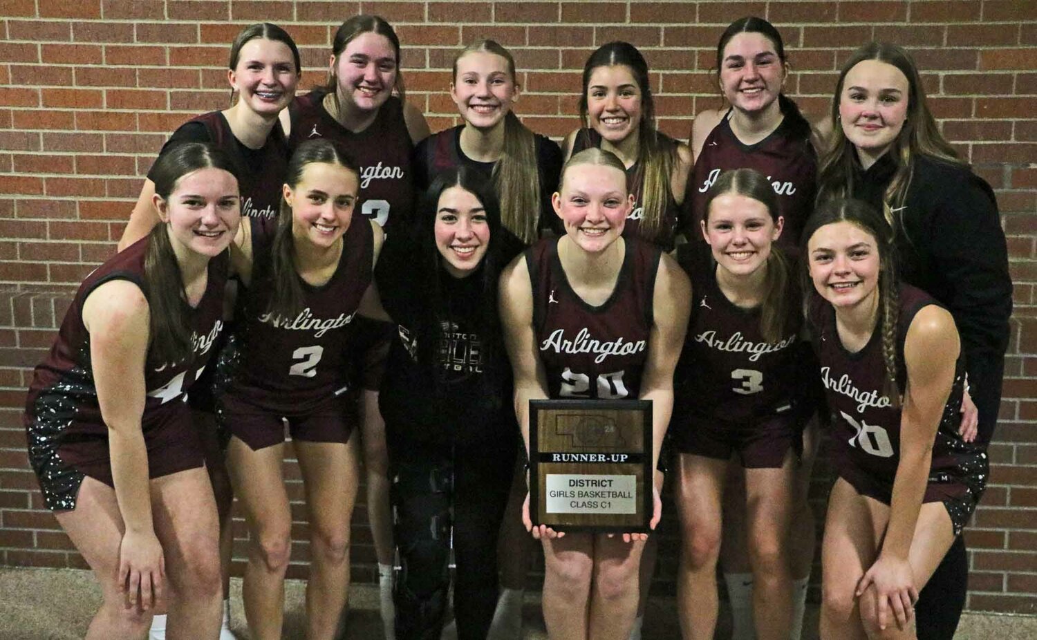 The Arlington girls basketball team poses for a photo with their Class C1 District Finals runner-up plaque Friday at Adams Central. Front row, from left: Gracen Adams, Emme Timm, Libby Hegemann, Austyn Flesner, Erika Cruikshank and Hailey O'Daniel. Back row: Britt Nielsen, Hayley Arp, Macy Wolf, Valeria Carvajal, Taylor Arp and Leah Franzluebbers.