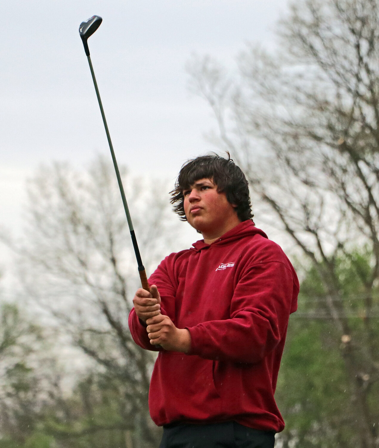 Arlington golfer Tyler Anthofer watches a tee shot Thursday at River Wilds Golf Club. The Eagles' home tournament started in rainy conditions.
