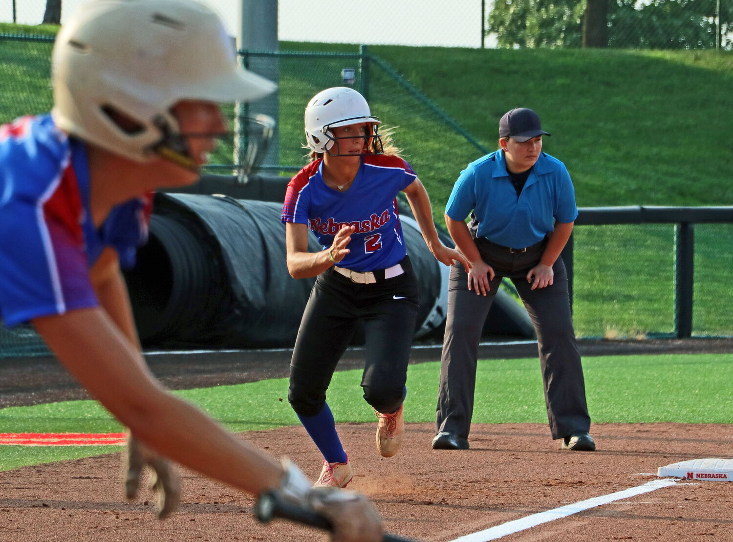 Leah Chance of Blair, middle, races home Monday during the Nebraska Coaches Association All-Star Game at Bowlin Stadium in Lincoln. The umpire pictured, Jessica Schenck, is a Blair graduate as well.