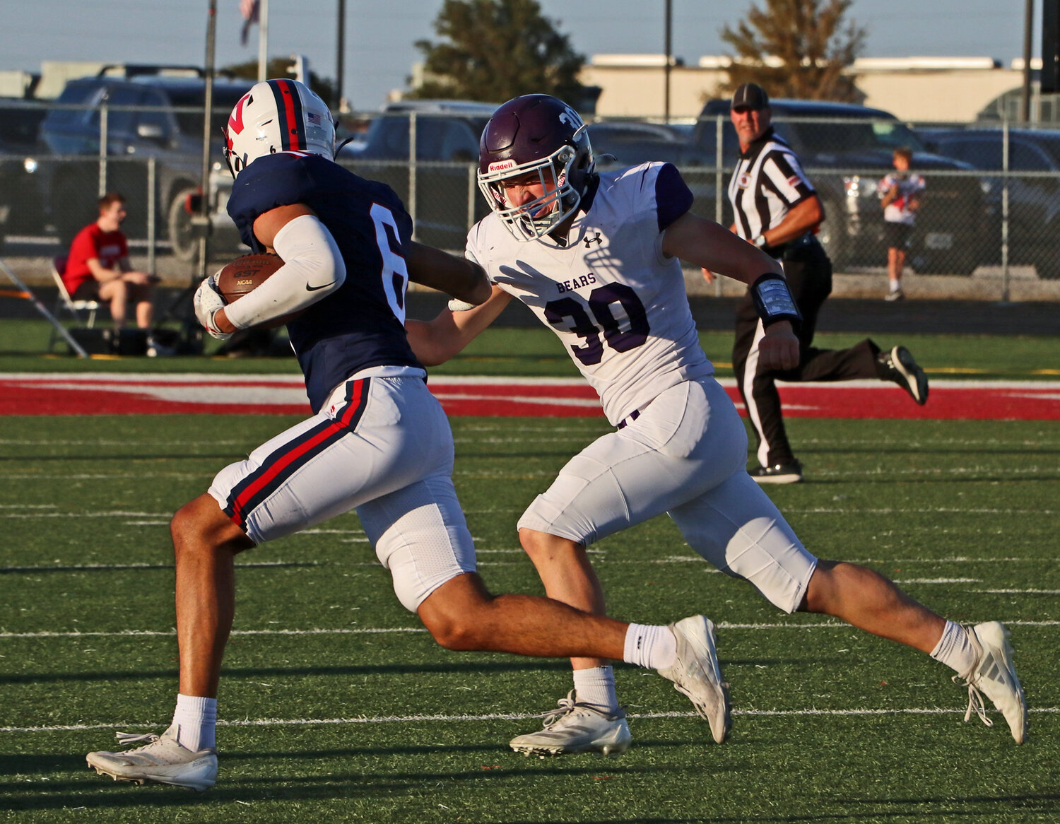 Blair defender Aidan Slominski, right, chases the Titans' Chris Garner Jr. on Friday at Norris High School. BHS fell on the road, 41-14.