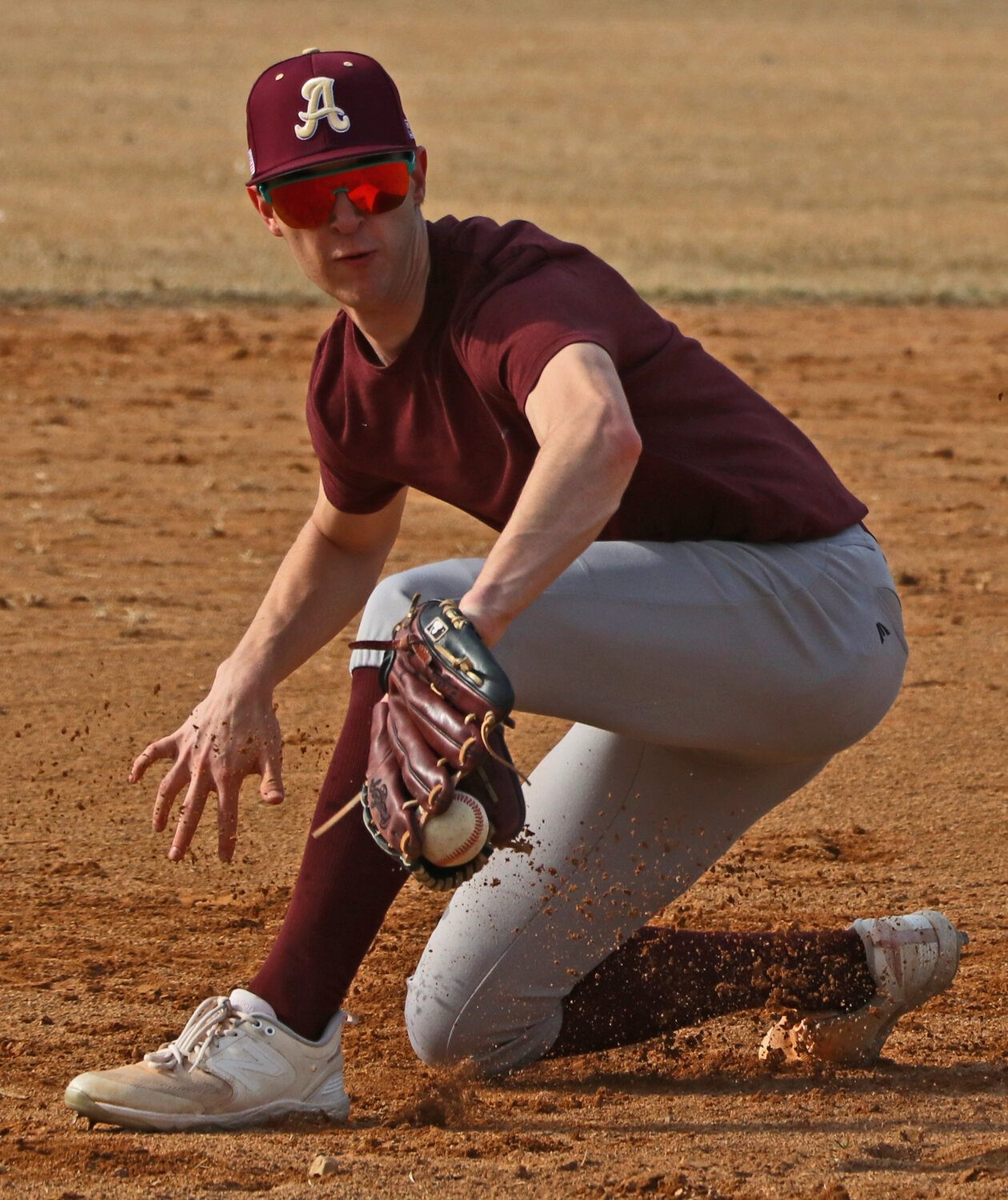 Third baseman Jackson Stosich backhands a ground ball March 12 during an Arlington baseball practice at the Washington County Fairgrounds.