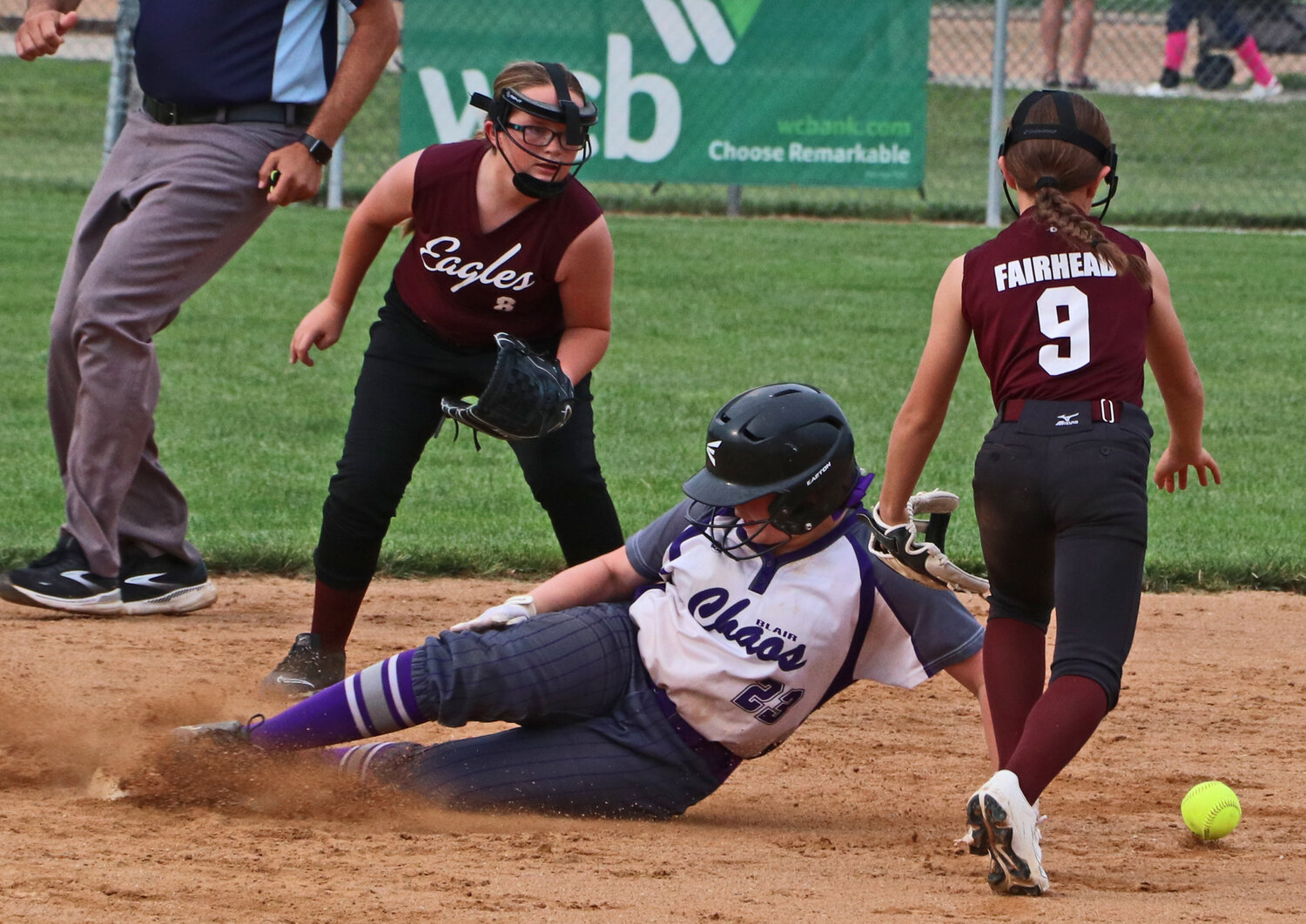 Chaos 12U base runner Genesis Heimann, middle, slides in safe at second base between Arlington infielders Mabel Lang, left, and Aspen Fairhead on Saturday at the Blair Youth Sports Complex. The Blair Youth Softball Association hosted USA Softball of Nebraska district competition on its home field during the weekend.