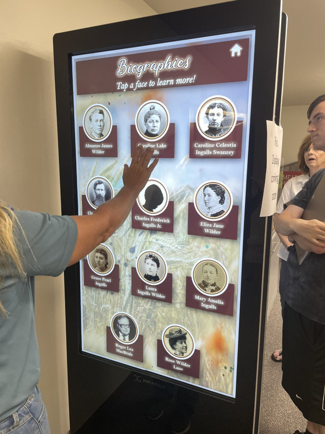 The Memorial Society's Anne Aamot demonstrates how to navigate through the kiosk content.