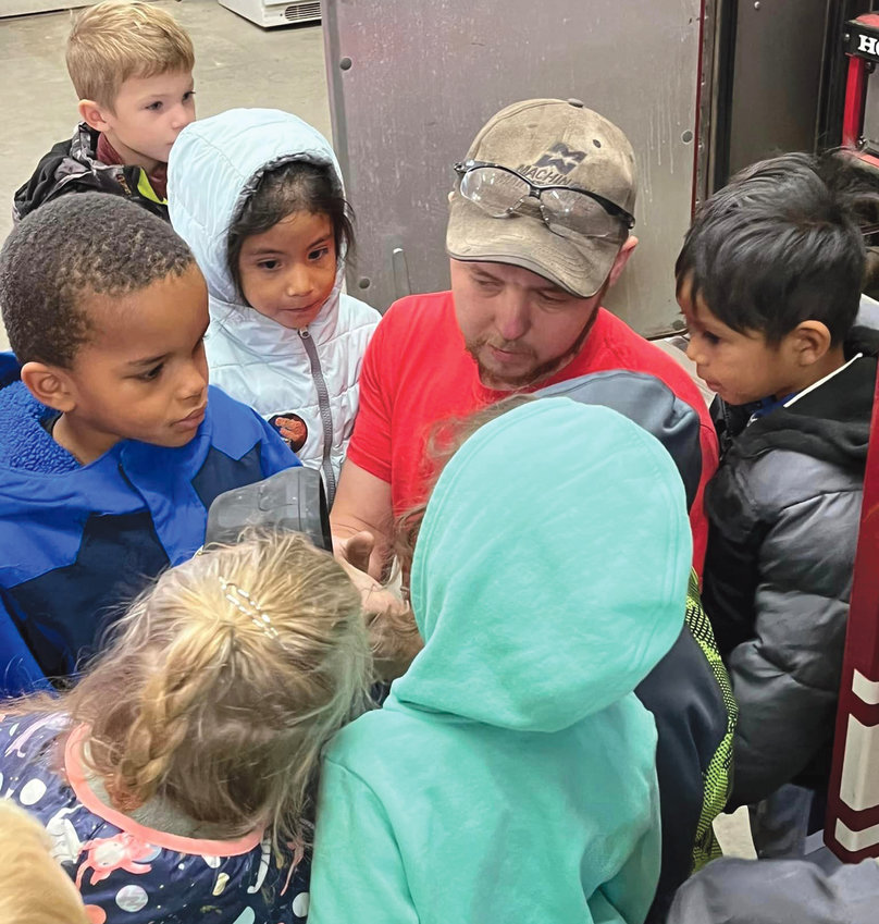Iroquois Volunteer Fireman Dale Unruh demonstrates the use of a fire nozzle to the the students of Iroquois Elementary School. Left, Qaixeon Auguston, Reed DeJong, Stefani Hernandez, Manuel Juarez Lopez, (facing forward.)