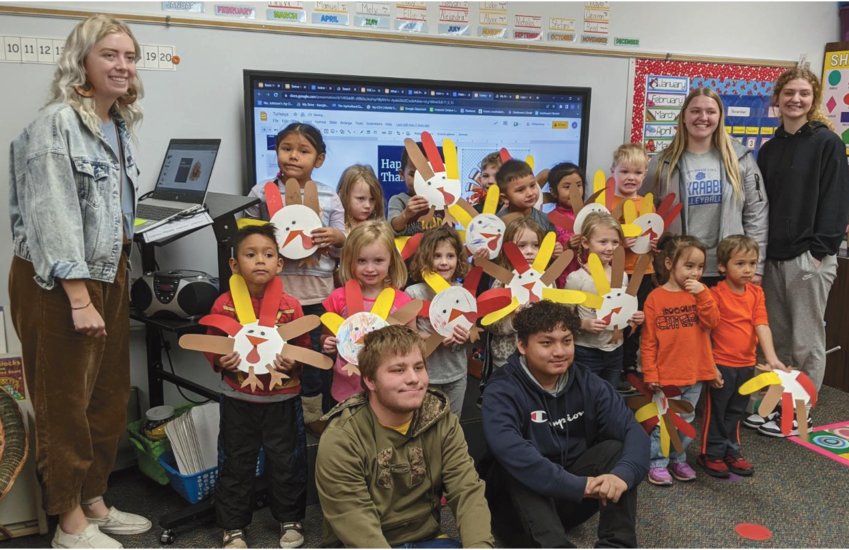 The Iroquois High School agricultural communication and leadership class, directed by the agricultural education teacher Ally Johnson, visited the Iroquois preschool class last week. They gave a PowerPoint presentation lesson on wild turkeys and commercial Thanksgiving turkeys. Afterward, the ag students helped the preschoolers make construction paper turkeys. &nbsp;Pictured are ag instructor Ally Johnson, back left, Mely Lucas Castro, Raeyah Peterson, Qai Augustin, Reed DeJong, Nicholas Paye, Stefani Hernandez, Luke Bechen, Kaylee Morehead, Anna Decker; Manuel Juarez Lopez, middle left, Maci Vincent, Ellie Blue, Mikayla Keating, Emma Dorris, Alejandra Siu Hansen, Alyxx Barth; Jace Murray, front left, and&nbsp;Say Htoo.