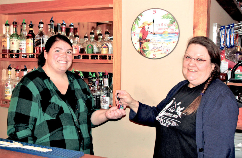 New owner Kaci Bechen, left, takes the keys for the Prairie Inn from previous owner Melanie Hamilton. Bechen officially took over the business on  Wednesday.