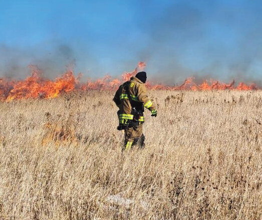 Lake Preston Fire Department crew members head off a fire by using a drip torch, a special can usually filled with a gas and diesel mixture, to back burn into the fire. In some instances, they actually light  fires to fight fires, depending on the situation or what is in the fire path ahead.