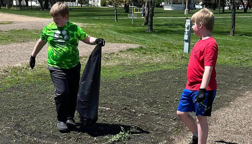 Alex and Logan Woodard help pick up trash in the city park during Lake Preston Elementary Community Clean-up Day.
