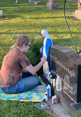 Mallen Kruger spent a beautiful evening using her artistic abilities to freshen up the paint on a statue in the St. Thomas Cemetery.