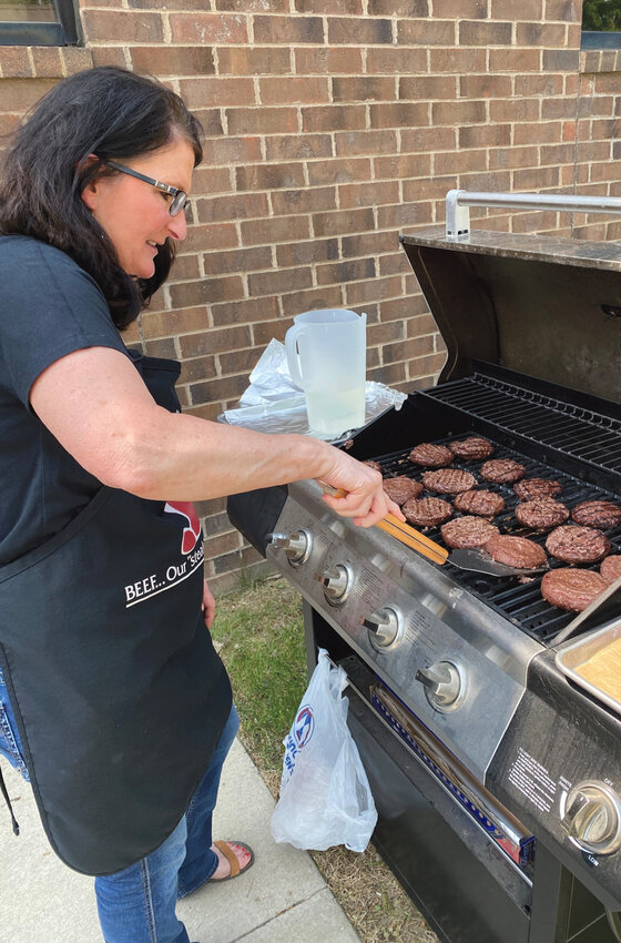De Smet Farm Mutual ended the month of May, Beef Month, by grilling out and employees sporting their agriculture t-shirts. Pam Hojer grills up the hamburgers, left, and Jennifer Duffy, left, Bailey Jensen and Frankie Freyberger wear their agriculture tees.