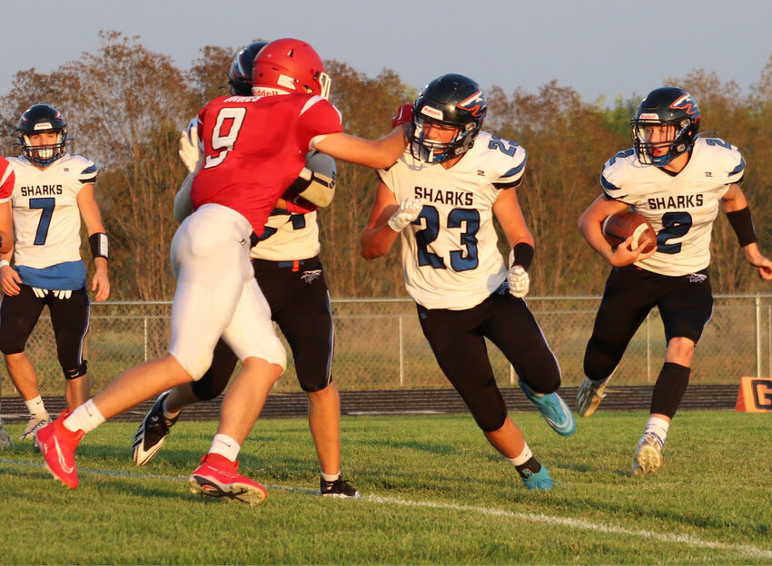 Sharks running back Lucas Pesky (2) looks for an opening behind blocking from Ben Curd (23) and teammates.