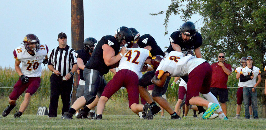 De Smet's Tristan Olson (42) and Trace Van Regenmorter (8) team up on a tackle of a Raider ball carrier, while Slayten Wilkinson (20) moves in to help finish the job.