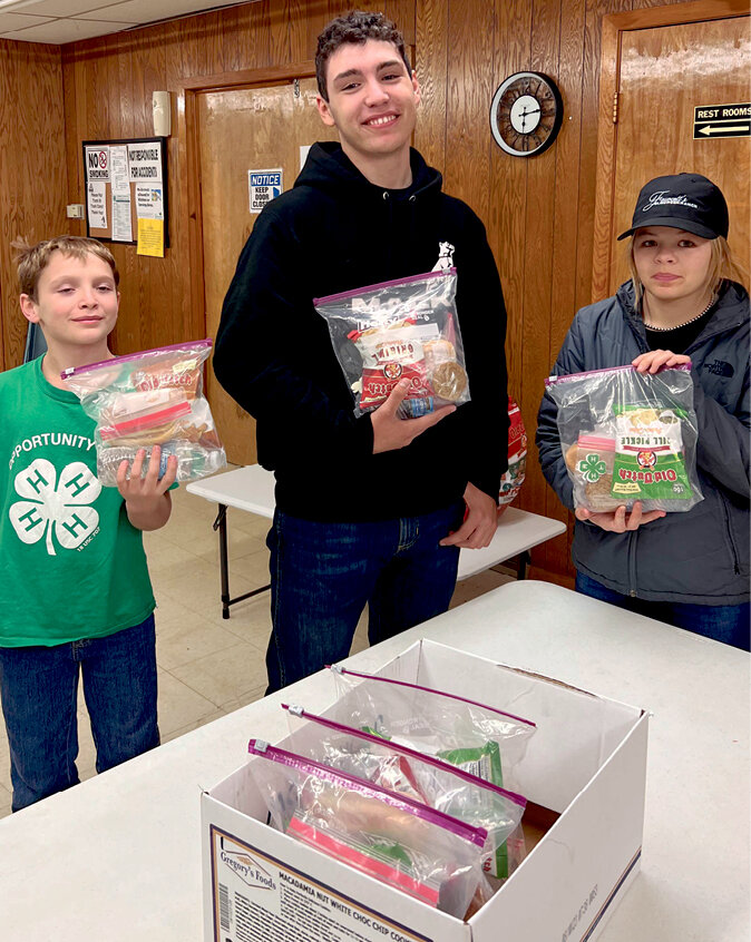 Cloverleaf 4-H Club met Oct. 9 to assemble meal bags for all employees working late hours at the grain elevators. Harvest meals were delivered to elevators in De Smet, Lake Preston, Bancroft, Carthage, Badger and Arlington. 4-H appreciates farmers and harvest workers. Awards night and dinner will be Nov. 5. Pictured are Willy Miller, Kirby Miller, Tabor Fawcett.