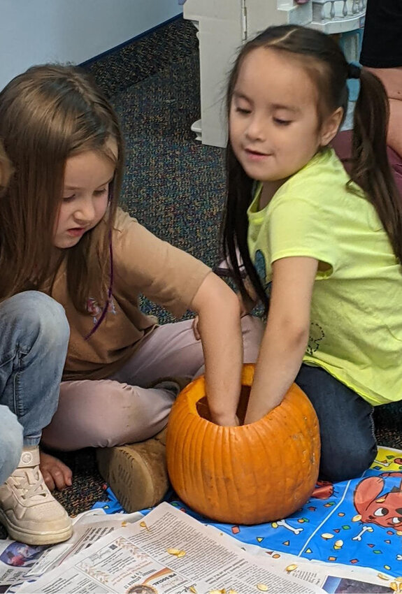 Iroquois preschool students watched pumpkins being carved into jack-o-lanterns then had fun cleaning out the insides of the pumpkins. This was a great sensory activity to explore their sense of touch, smell and sight.&nbsp;Saylor Hanzlik and Alejandra Sui Hansen pull seeds and pulp out of a pumpkin.