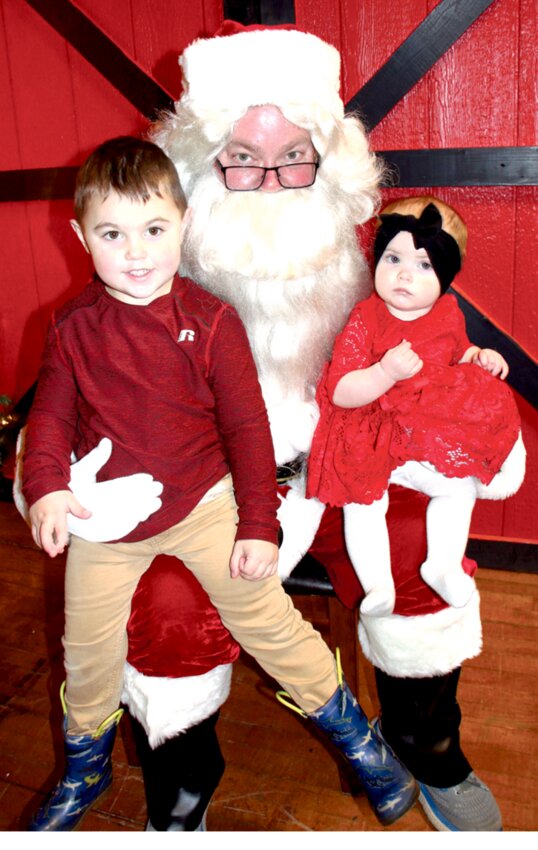 Lynkin and Eden Ficek of De Smet visit with Santa Claus Sunday in the backroom of Klinkel&rsquo;s III during the De Smet Chamber-sponsored Christmas Tree Festival.
