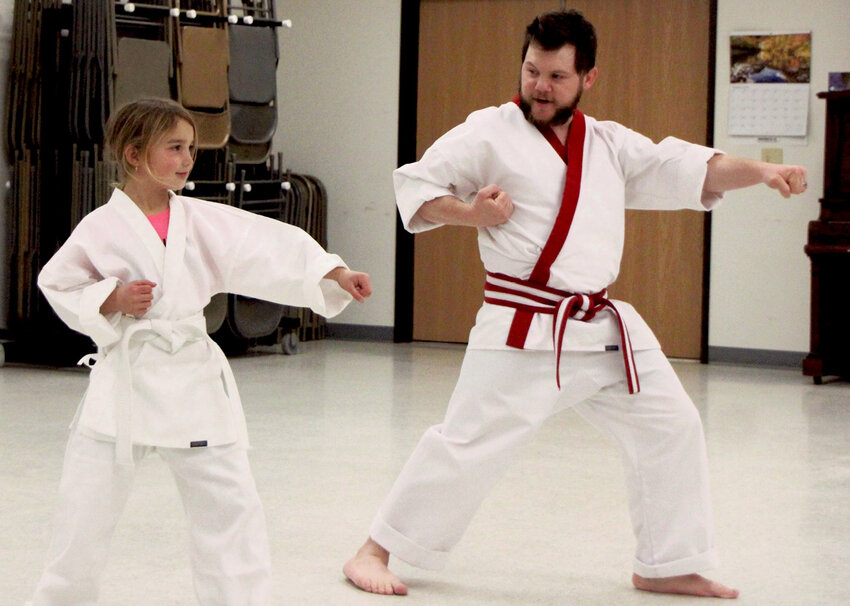 Instructor Patrick Burger goes through some moves with student Bryer Stevens.