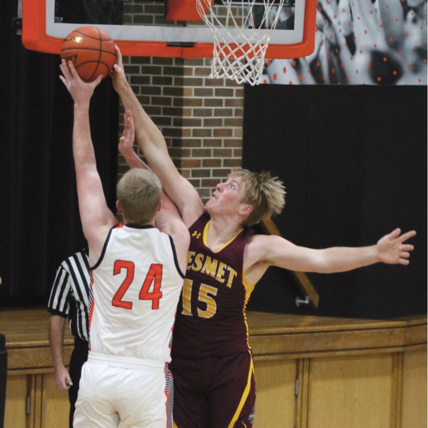 De Smet senior Trace Van Regenmorter (15) goes up for a block on Howard's Luke Koepsell (24) last Tuesday in Howard. The Bulldogs defeated the Tigers 56-44.