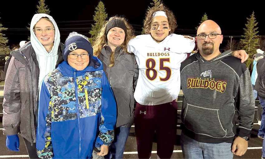Leah, Grayson, Julie and Jim Millman get a picture with Deloye after a football game this past season.