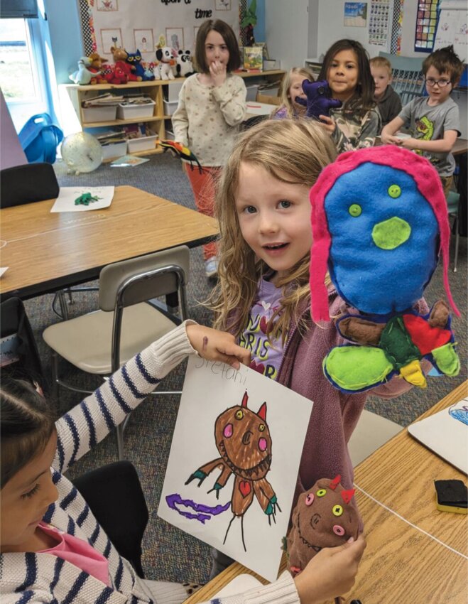 At Iroquois Middle School, Nancy Weir's kindergarten class and the eighth-grade Family and Consumer Sciences (FACS) class teamed up for a special project.  Weir read the story, &ldquo;I Need My Monster.&rdquo; The kindergarteners drew monster pictures, and the eighth graders used felt, buttons and colorful threads to turn those drawings into cute plush dolls. This project brought everyone together in a fun way and taught both groups of students new skills.  The unveiling ceremony was filled with excitement and laughter, showing how working together can make something special for the whole school to enjoy.