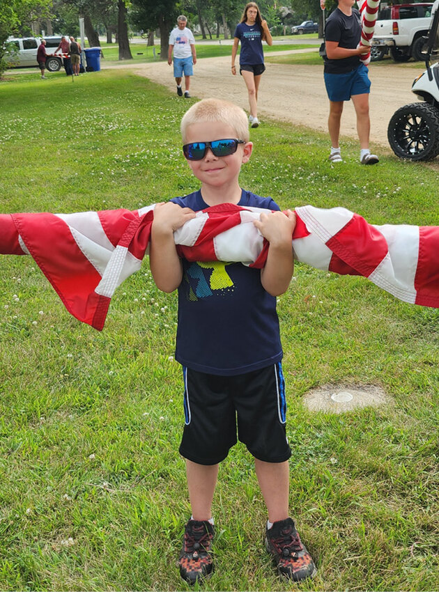 When the rain started on Sunday evening, it was a scramble to take the flags down at the park and the cemetery. One of the best helpers called into action was Logan Buer. All flags got in before any rain.