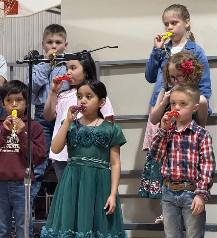 First- and second-grade students, Cason Glanzer, back, Isabelle Rose; Audrina Smith, middle, Rowena Guthmiller; Manuel Juarez Lopez, Alice Lopez Batolon and Levi Waldner, under the direction of Mrs. Teresa Decker, play their kazoos during their &quot;Beat in My Feet&quot; song at the Iroquois Elementary Spring Concert.